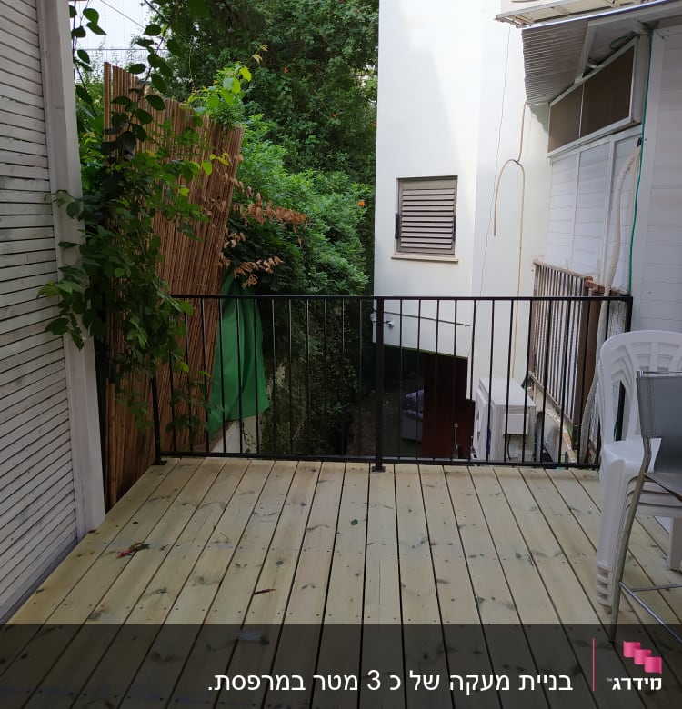 מרפסת עץ עם מעקה מתכת וצמח מטפס